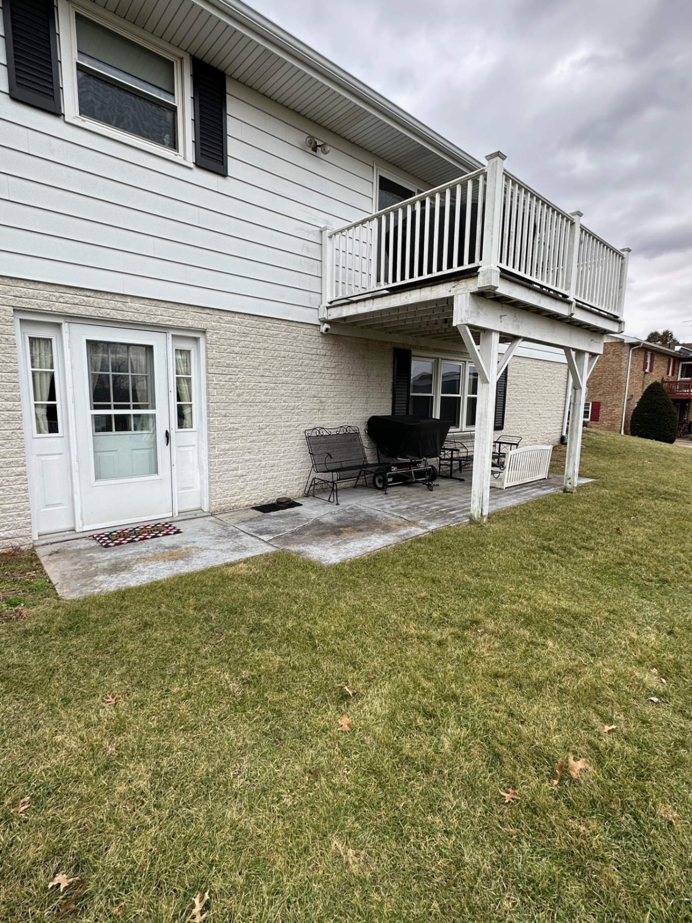 Before — aged white painted deck above brick patio — Caliber Build · 08